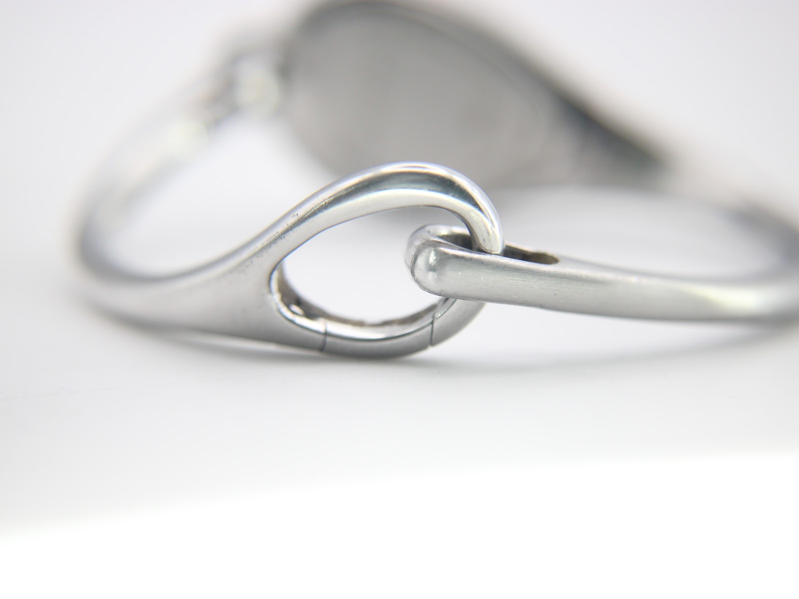 Close-up of the integrated bangle clasp mechanism, a simple yet elegant hook-and-eye design.