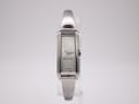 Front view of the silver Gucci 109 rectangular quartz watch on a clear display stand.