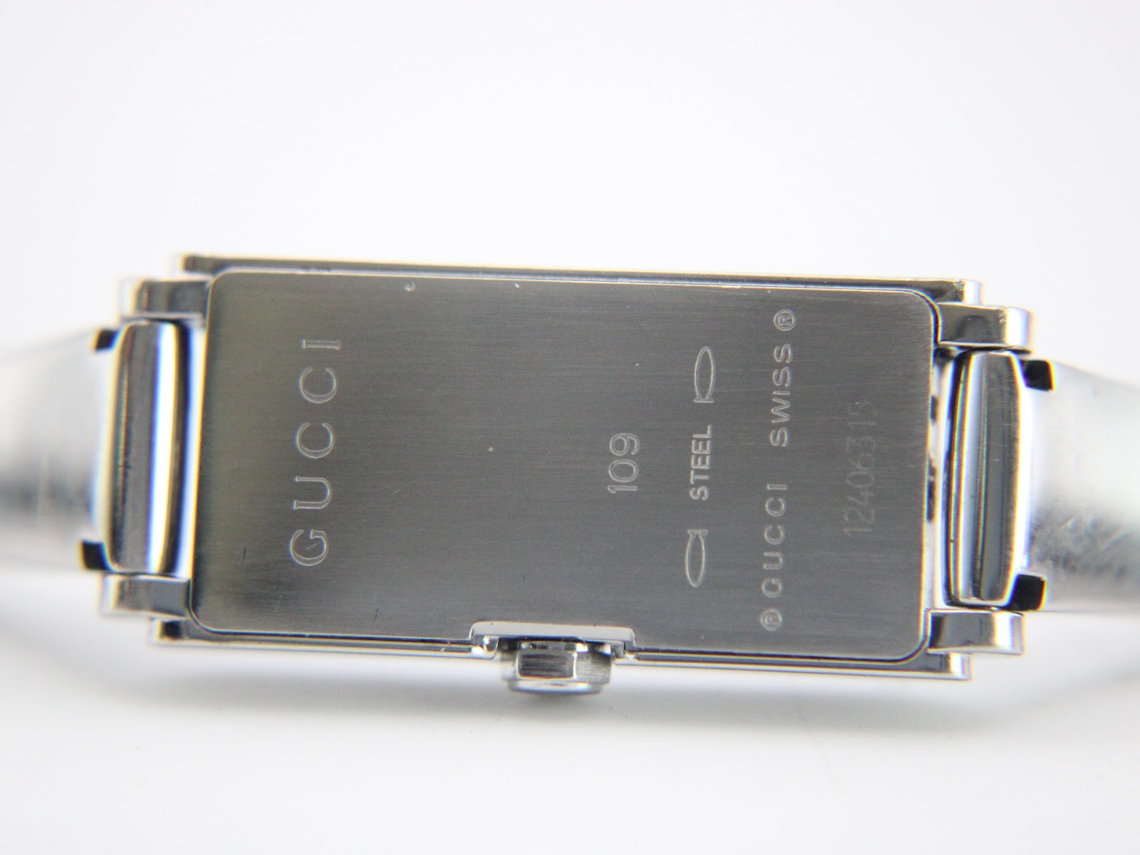 View of the brushed stainless steel case back, engraved with 'GUCCI', '109', 'STEEL', 'SWISS', and serial number.