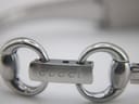 Macro shot of the integrated bracelet's push-button deployant clasp, with 'GUCCI' engraved on the buckle.