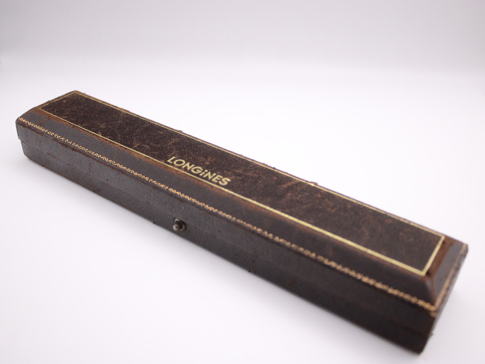 External view of the vintage Longines presentation box, showing its brown leatherette finish and gold trim.