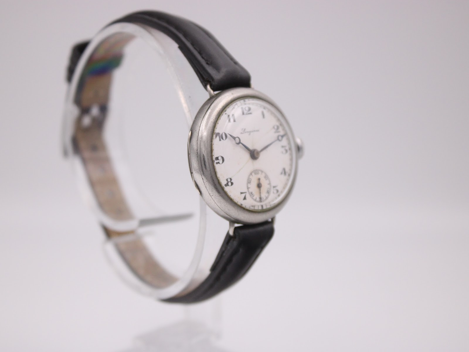 Another angled view of the vintage Longines watch, showing the case profile and the black leather strap.
