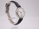 Another angled view of the vintage Longines watch, showing the case profile and the black leather strap.
