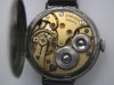 Close-up of the open hinged case back, revealing the gold-toned manual wind Longines movement with serial number 5324374.