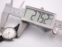 Digital caliper measuring the Longines watch case diameter, showing an exact reading of 27.52mm.