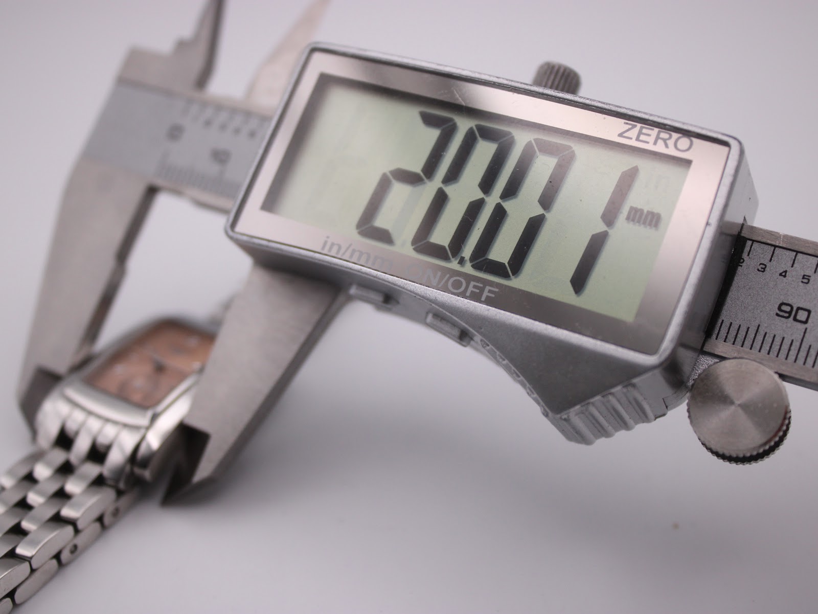Close-up of a digital caliper measuring the case width of the Longines watch, displaying 20.1mm.
