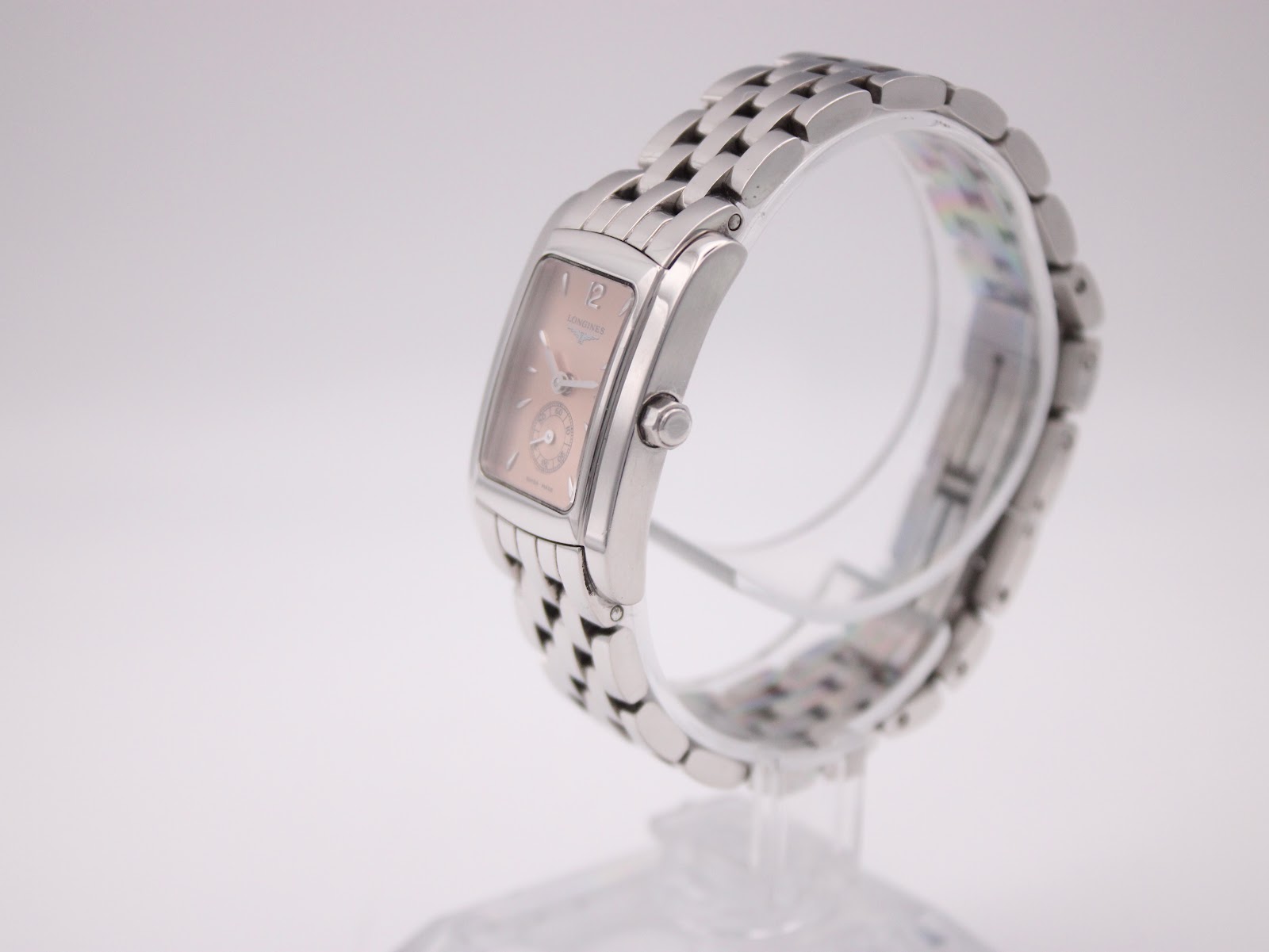 Side profile view of the Longines watch on a clear display stand, highlighting the rectangular case and bracelet.