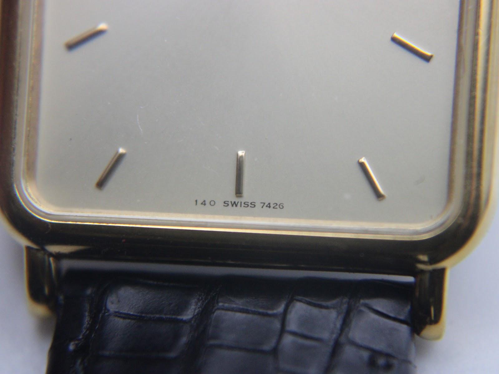 Extreme close-up of the watch dial's lower half, clearly showing "140 SWISS 7426" text below the 6 o'clock index.