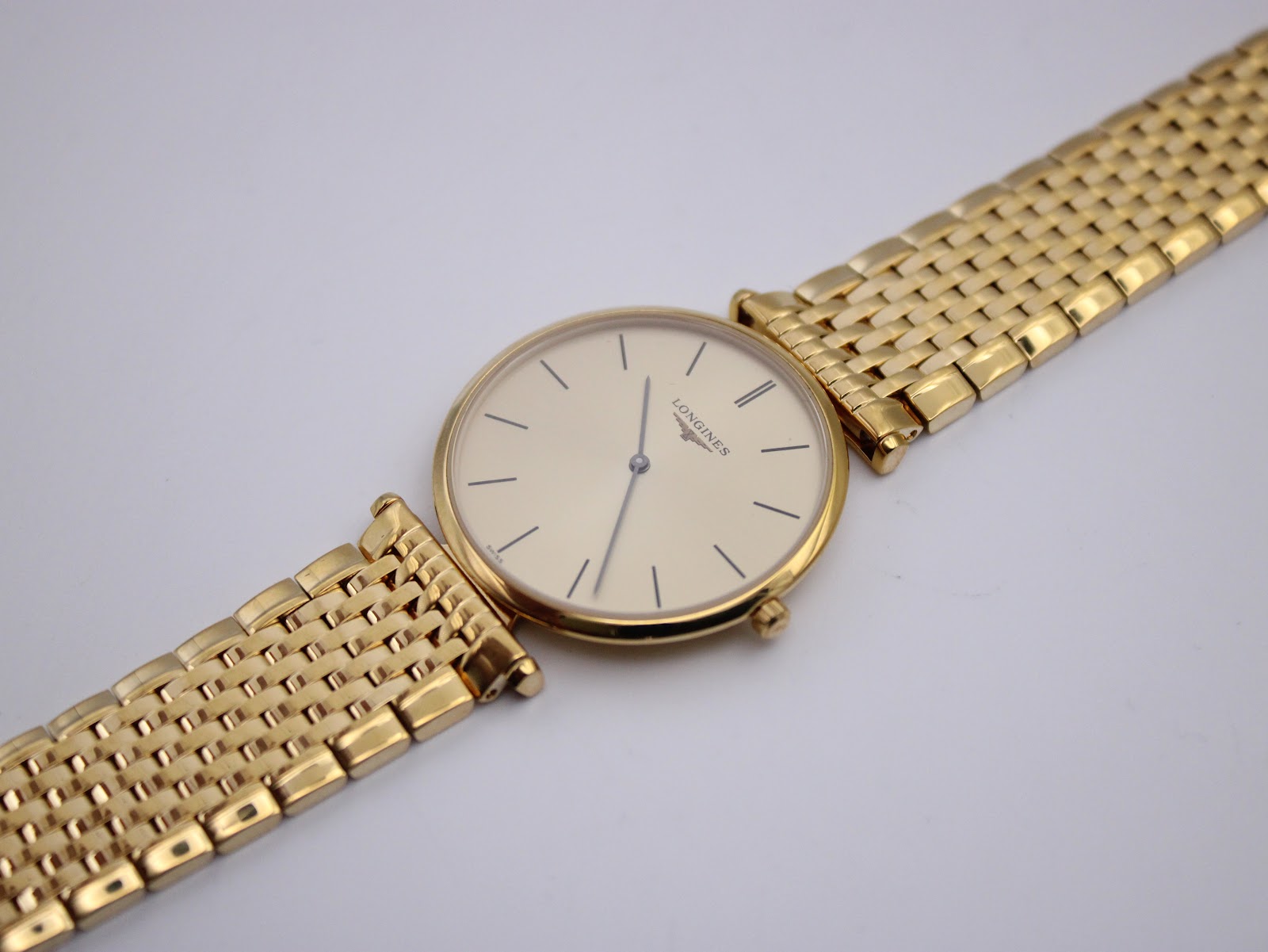Overhead view of the Longines watch with the gold multi-link bracelet laid flat, showcasing the overall design.