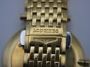 Close-up of the Longines signed deployment clasp on the gold multi-link bracelet.