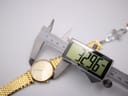 Digital caliper measuring the case diameter of the Longines watch, displaying 32.96mm.