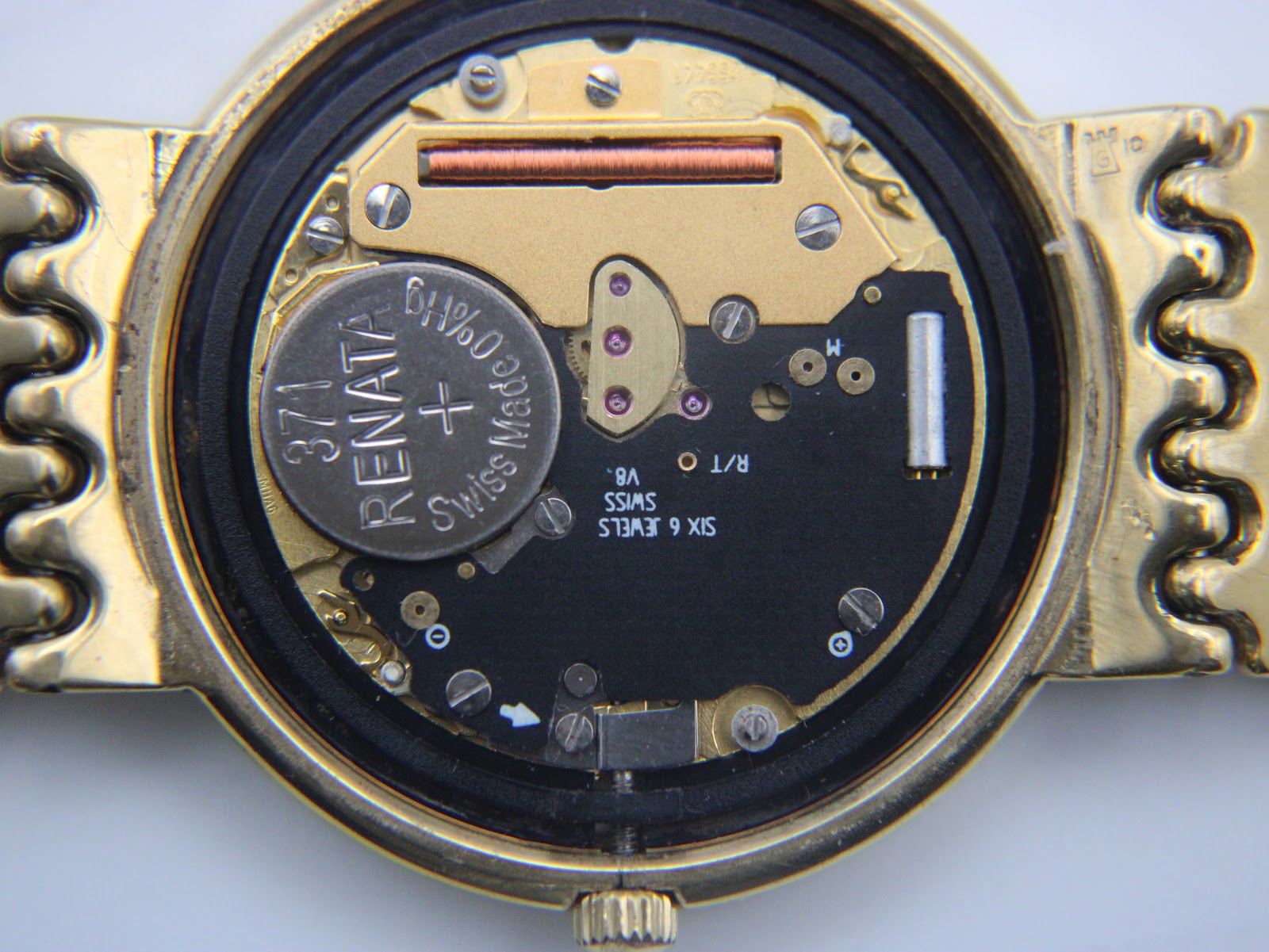 Detailed close-up of the Swiss quartz movement inside the Longines watch, with a newly fitted Renata 371 battery and "Six 6 Jewels Swiss V8" inscription.