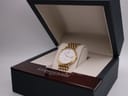 The Longines Flagship watch presented inside its open original dark blue and wood-effect Longines box, on a white cushion.