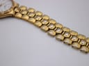 Close-up of the gold-tone integrated bracelet links, showing some wear on the underside/edges.