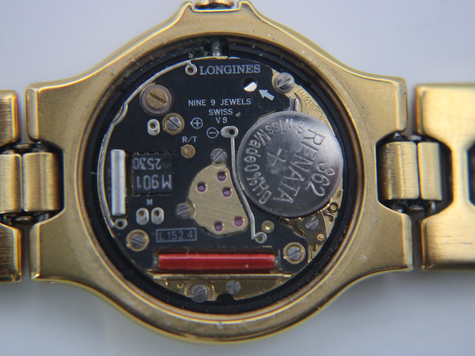 Macro view of the Longines quartz movement with 'Nine 9 Jewels Swiss V8' and Renata battery.