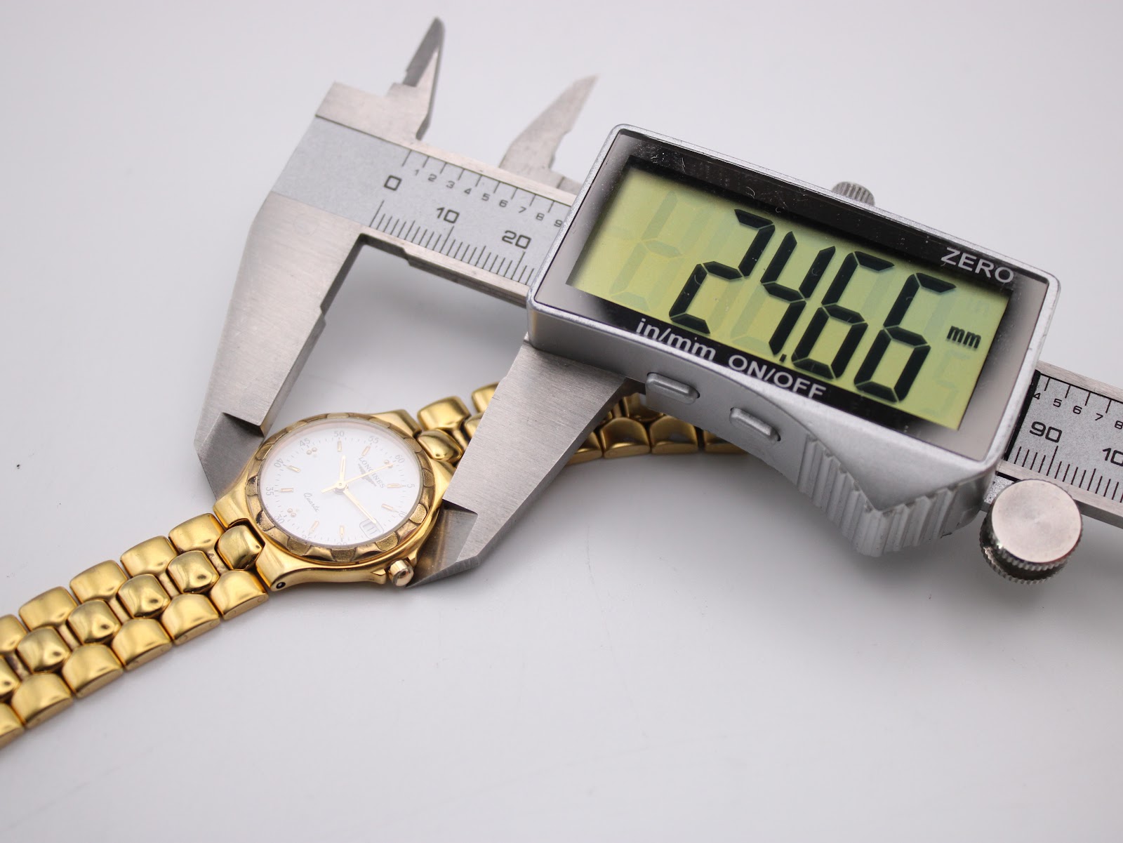 Digital caliper measuring the case diameter of the Longines Conquest watch at 24.66mm.