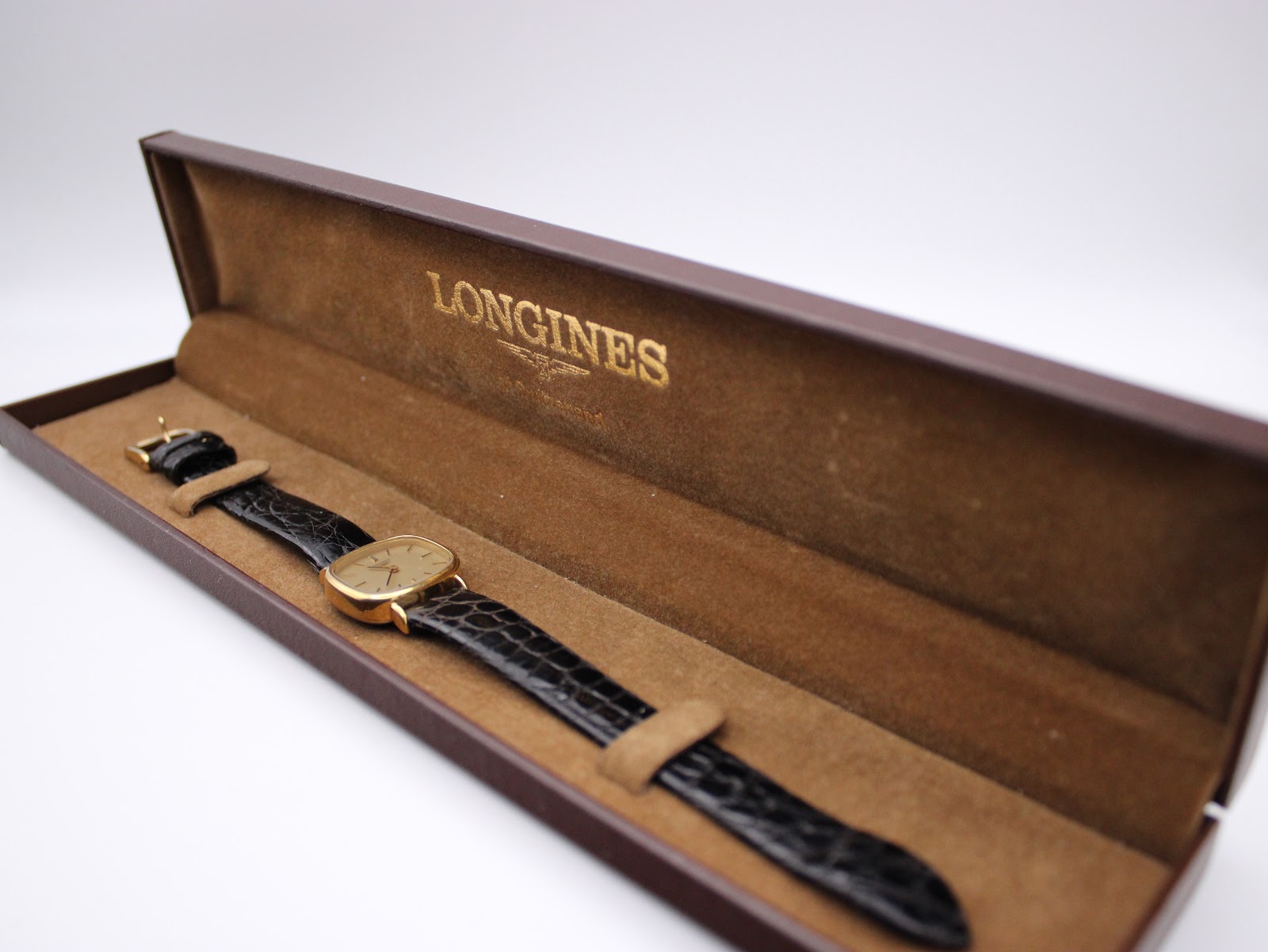 The Longines watch presented inside its original brown Longines box.