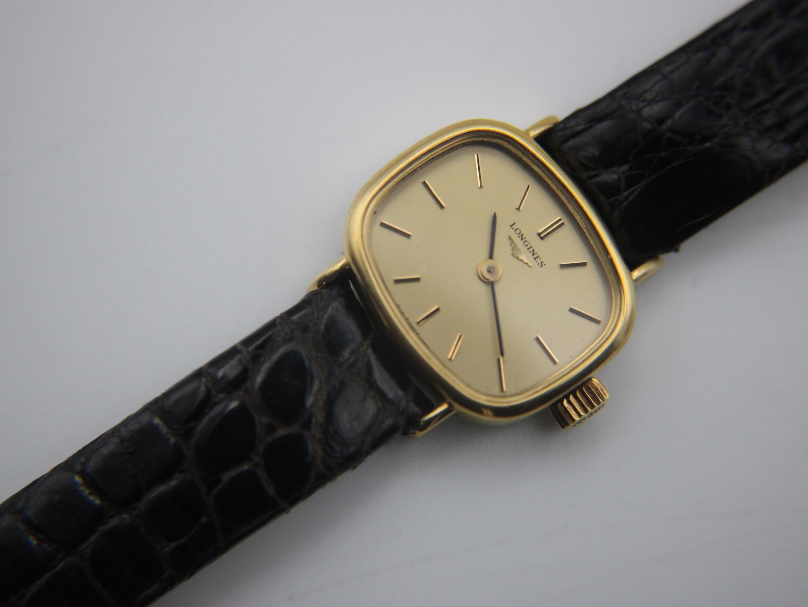 Close-up angled view of the Longines watch dial, hands, and case.
