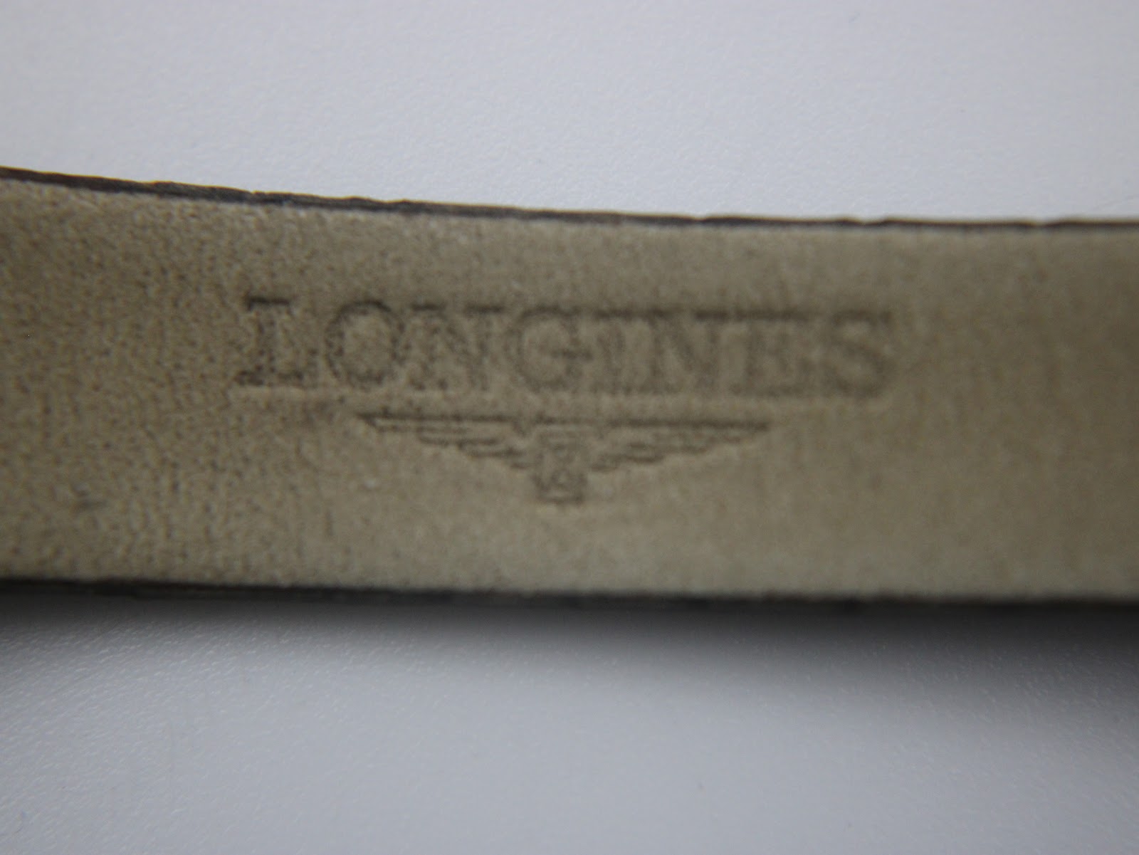 Close-up of the interior of the leather strap, showing embossed Longines logo.
