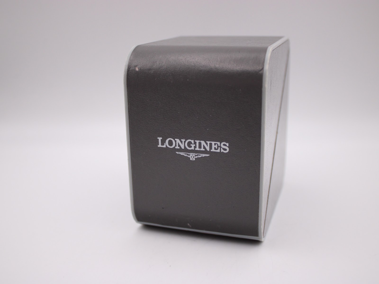 Closed view of the original grey Longines watch box, with the Longines logo visible on the lid.