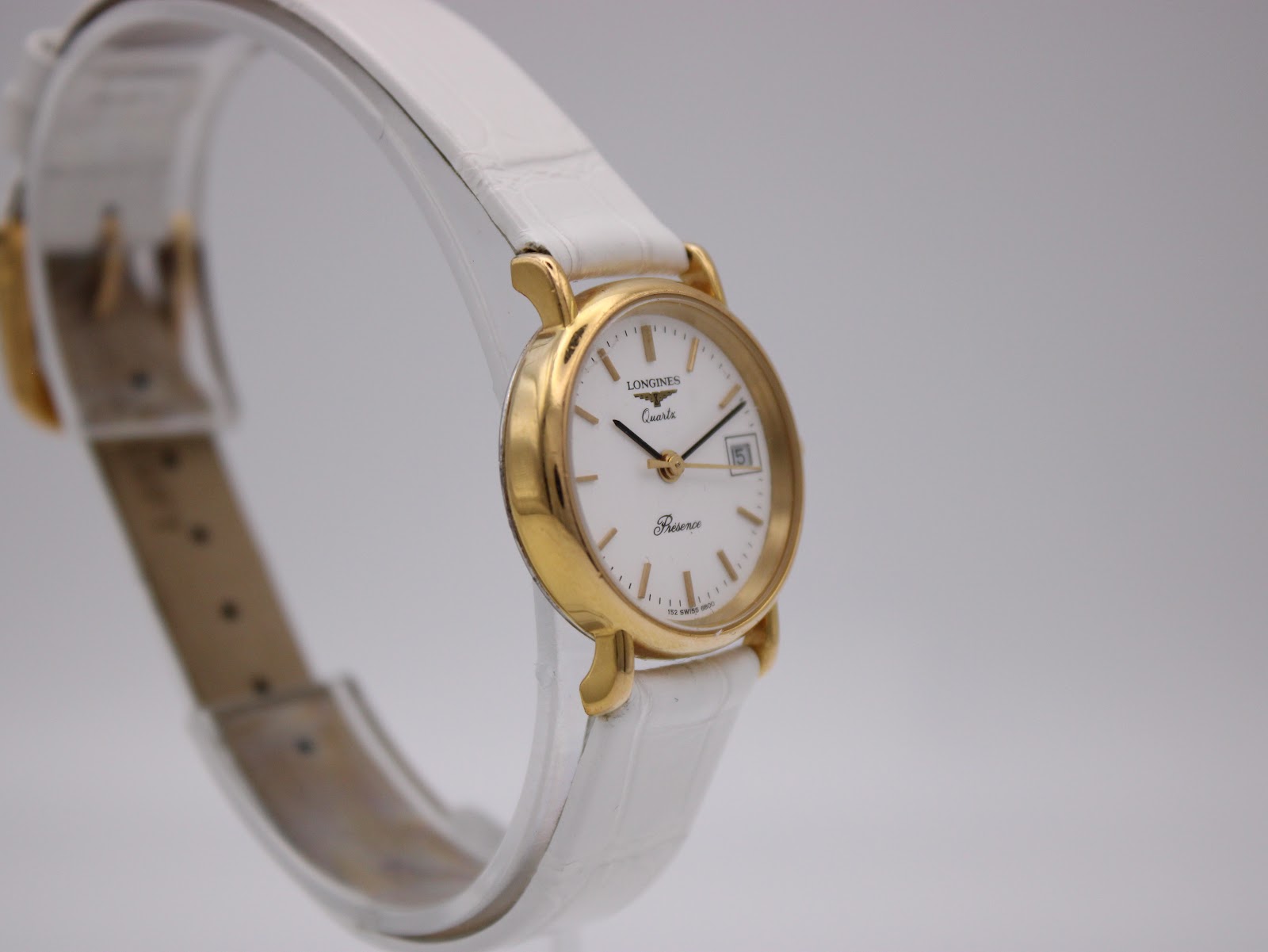 Angled side view of the Longines Presence watch on a display stand, showcasing the opposite side of the gold-tone case.
