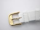 Close-up shot of the gold-tone buckle, showing its classic design.