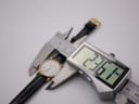 Digital caliper measuring the Longines watch case diameter, showing a precise reading of 23.61mm.