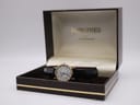 Front view of the Longines watch with white dial and black leather strap, presented in its original brown box.