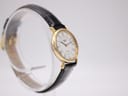 Another angled side view of the Longines watch, showing the elegant lugs and the curvature of the case on a clear stand.
