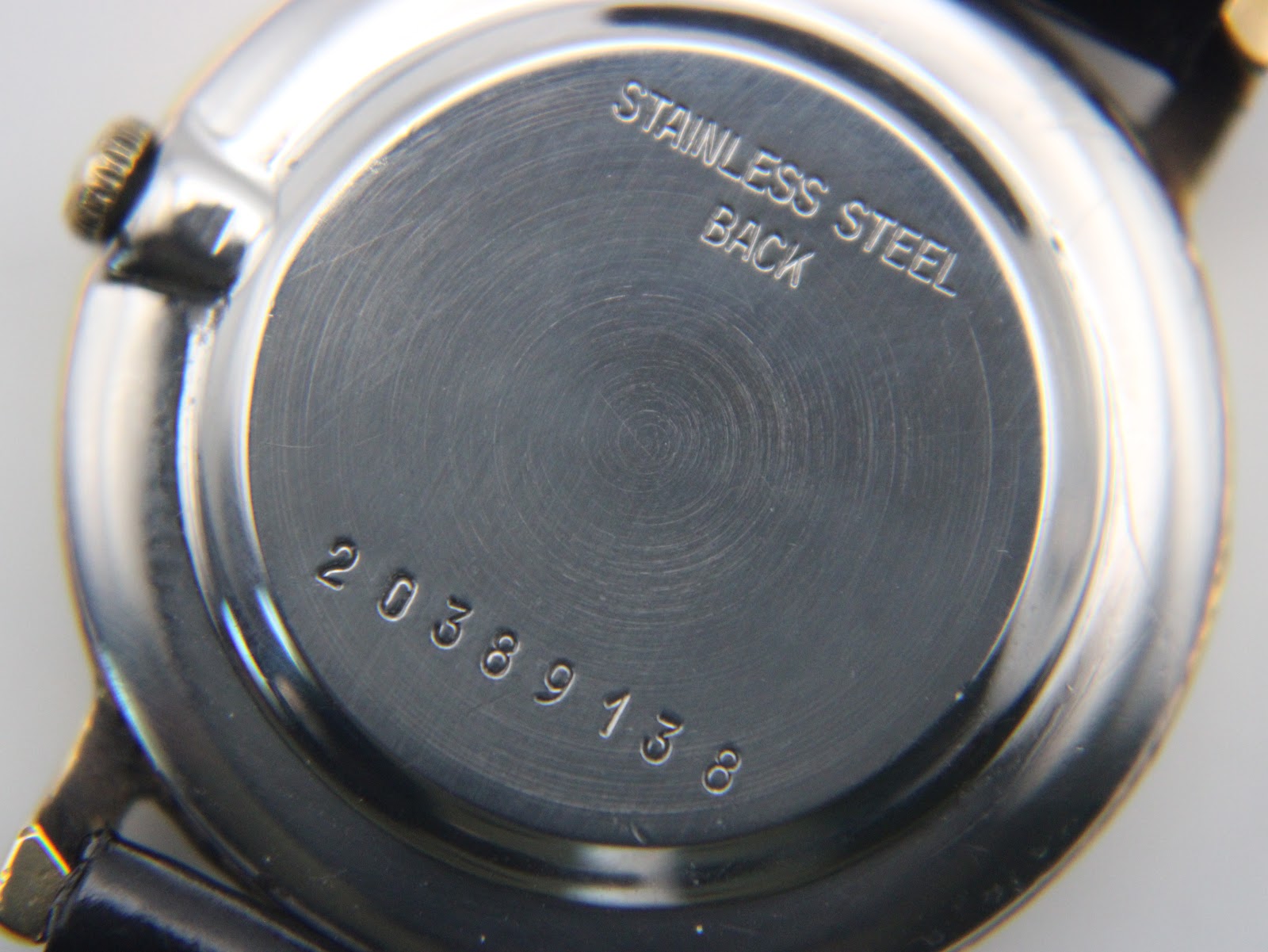 Close-up of the polished stainless steel case back, engraved with 'STAINLESS STEEL BACK' and the serial number '20389138'.