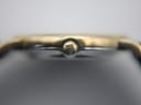 Macro shot of the watch crown, clearly showing the embossed Longines winged hourglass logo.