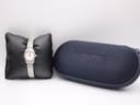 Longines L4.215.4 watch on a black cushion next to its original navy blue Longines travel case.