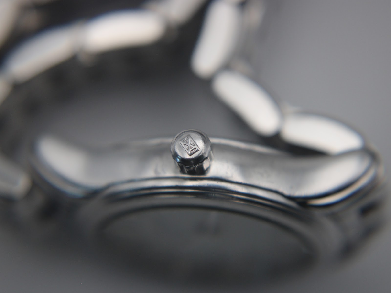 Close-up of the watch crown, featuring the embossed Longines winged hourglass logo.