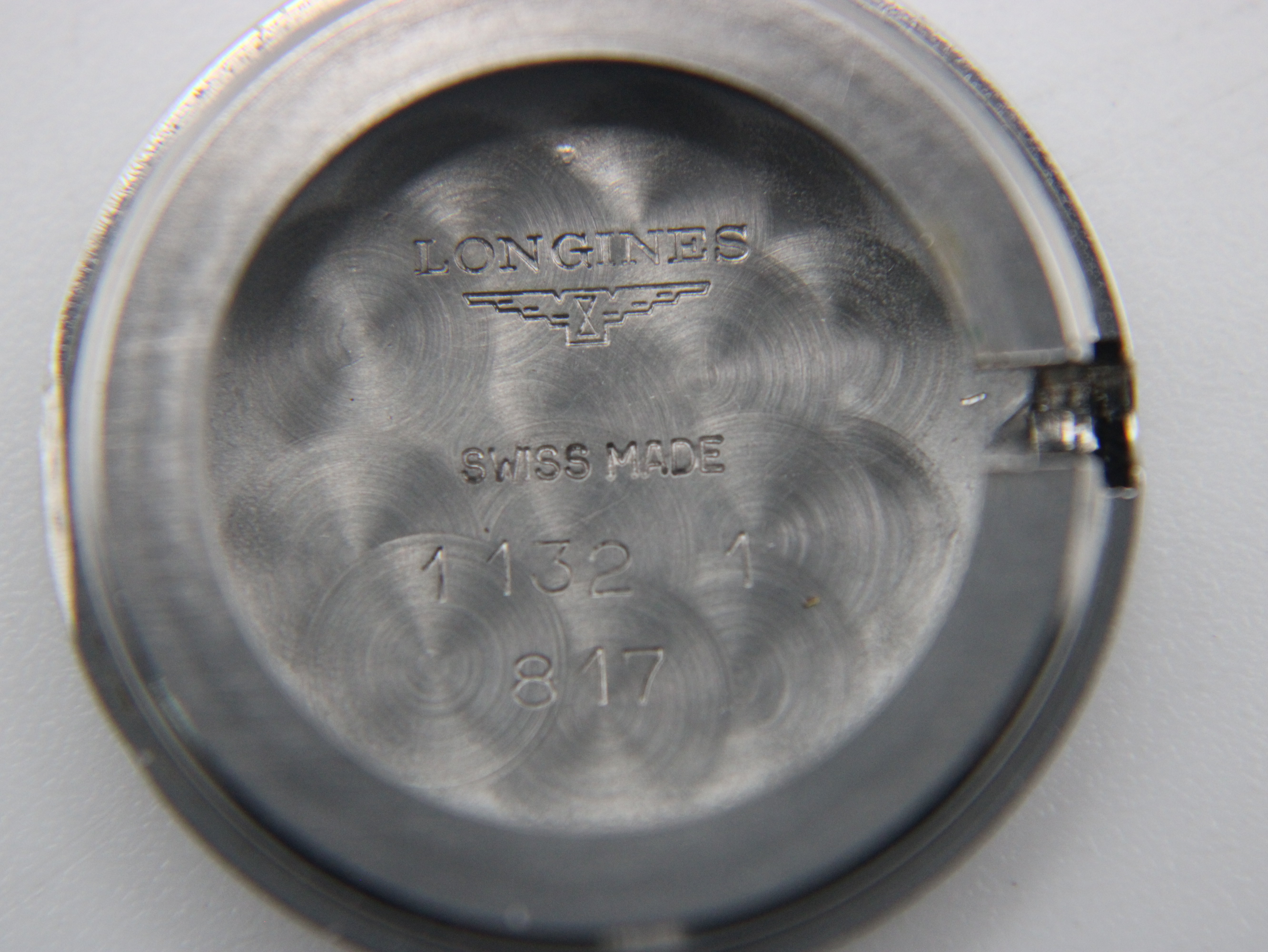 Interior view of the stainless steel case back, showing the Longines logo, 'Swiss Made', and model numbers '1132' and '817'.