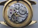 Close-up side view of the fluted gold-tone crown, clearly showing the embossed Longines winged hourglass logo.