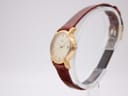 Angled side view of the Longines L4.197.2 watch, highlighting the gold case and brown strap on a watch stand.