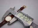 Watch case being measured by a digital caliper, displaying a precise diameter of 22.20mm.