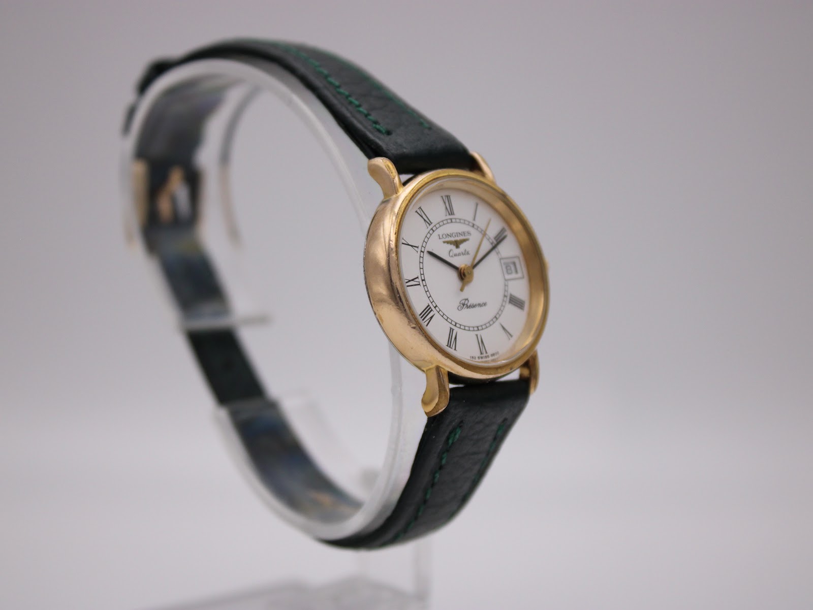 Angled left-side view of the Longines Presence watch highlighting the case profile and green strap.