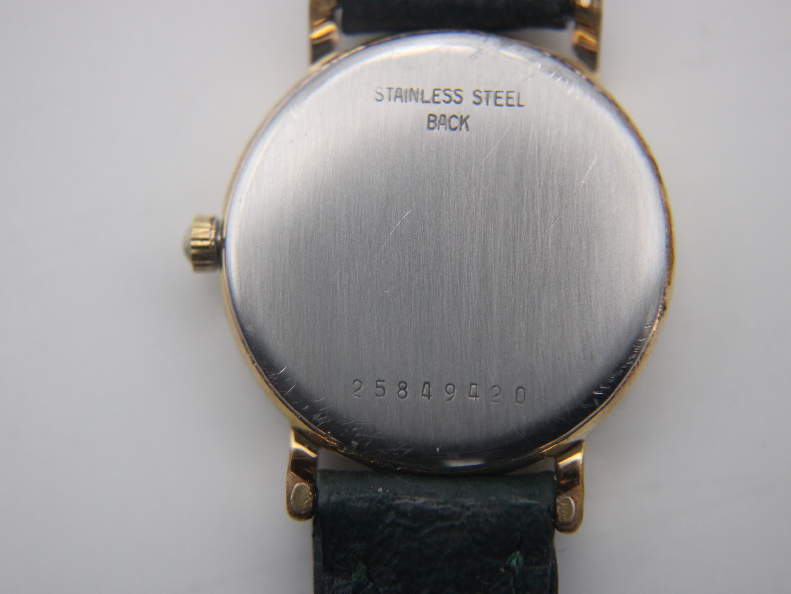 Close-up of the watch's stainless steel case back with serial number 25849420 engraved.