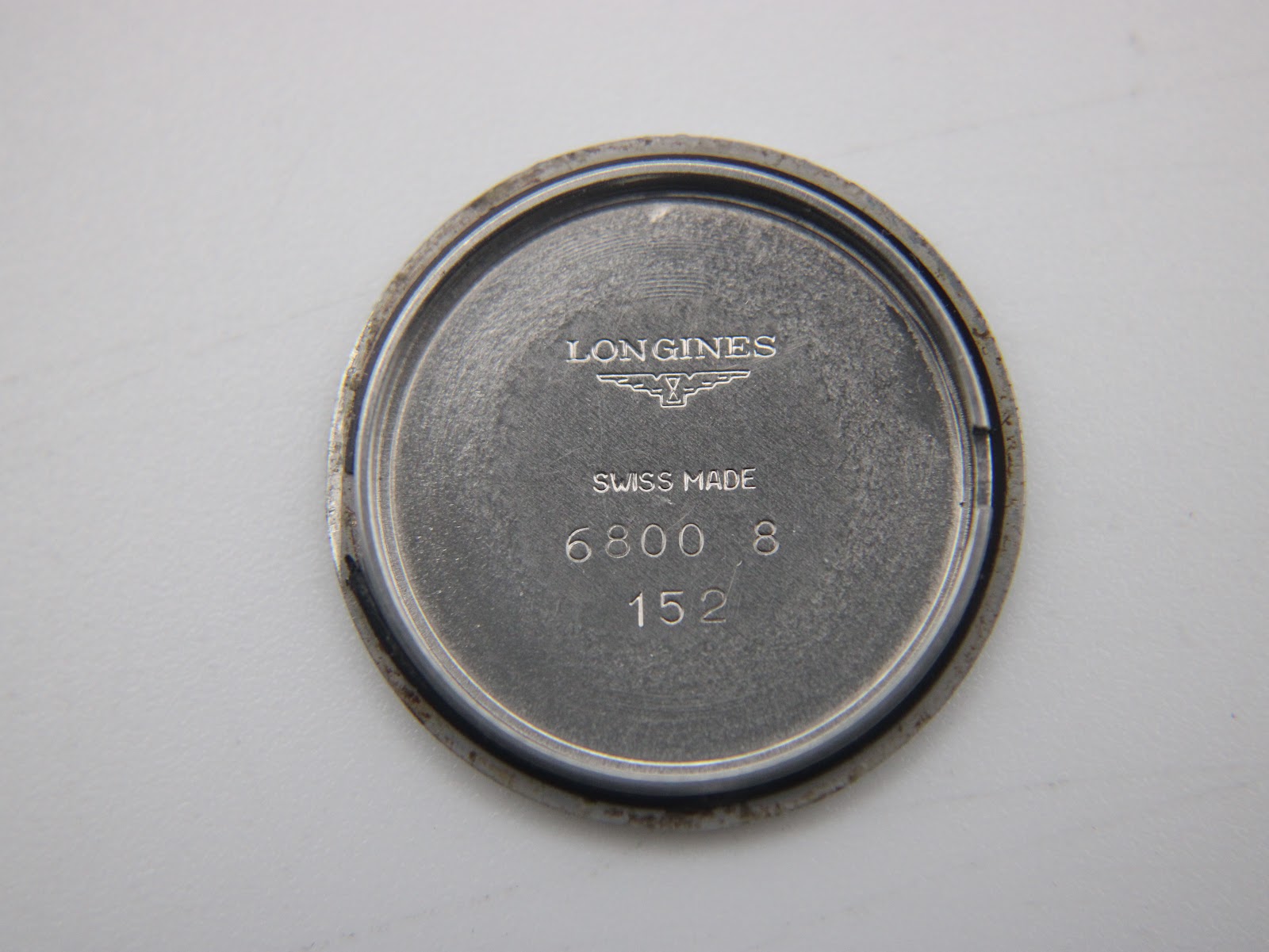 Inner side of the stainless steel case back showing 'Longines Swiss Made 6800 8 152' engravings.