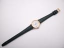 Full length view of the Longines Presence watch and green leather strap laid flat.