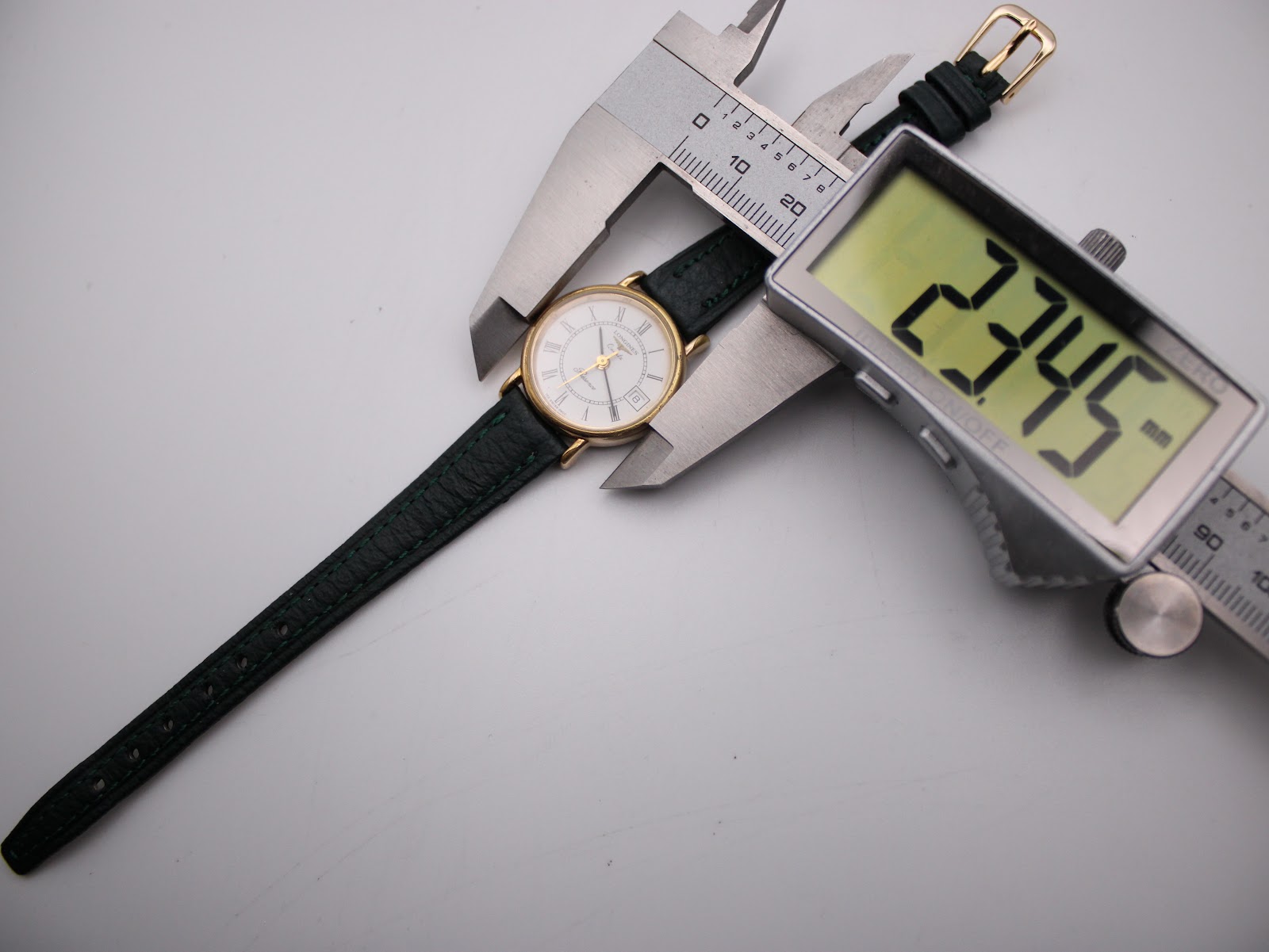 Digital caliper measuring the case diameter of the Longines Presence watch at 23.45mm.