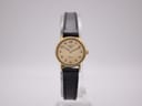 Front view of the Longines Presence watch on a stand, showing the gold-tone case, cream dial, and black leather strap.
