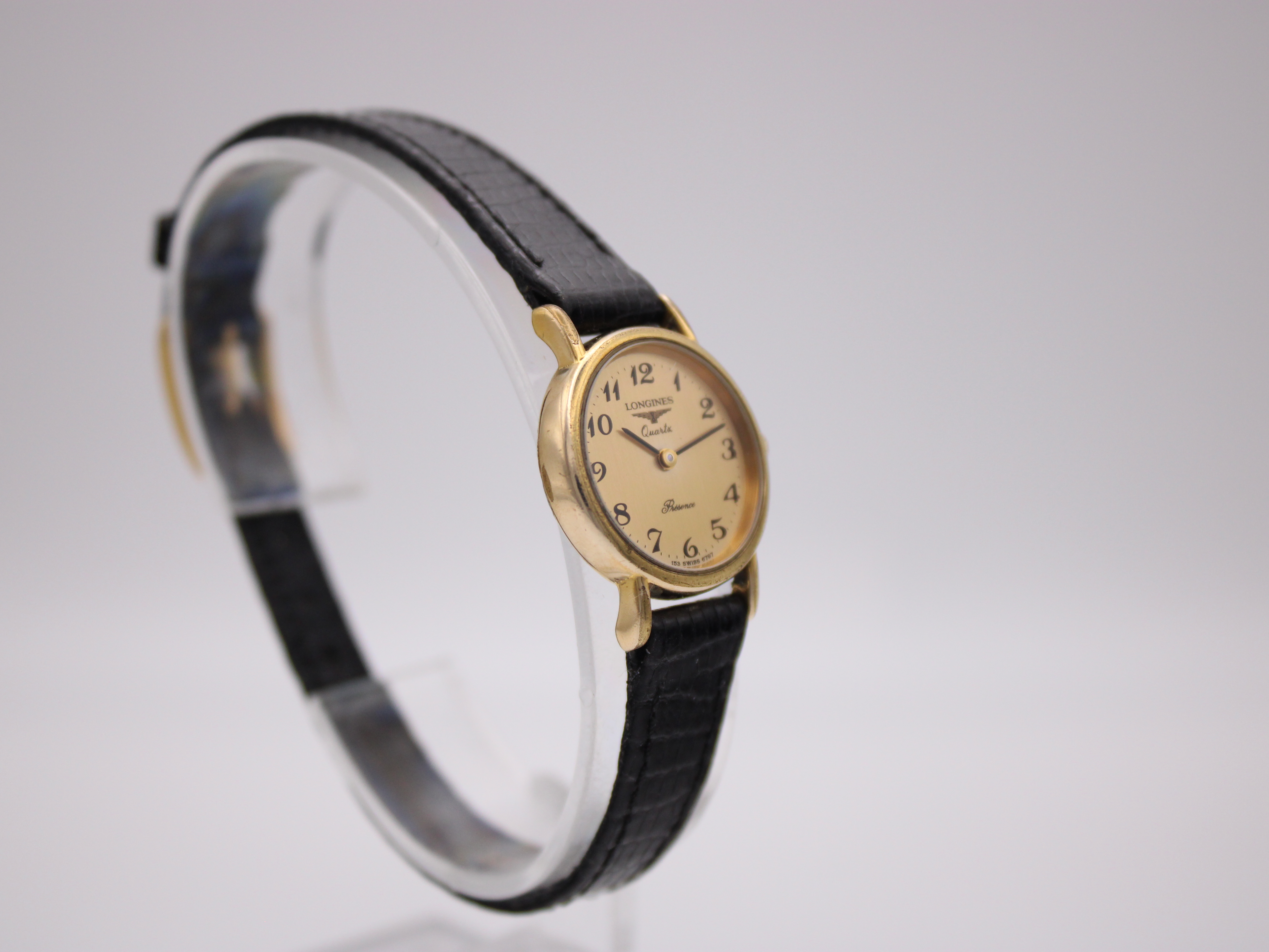 Another angled view of the watch, showcasing the full length of the black leather strap.