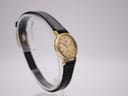Another angled view of the watch, showcasing the full length of the black leather strap.