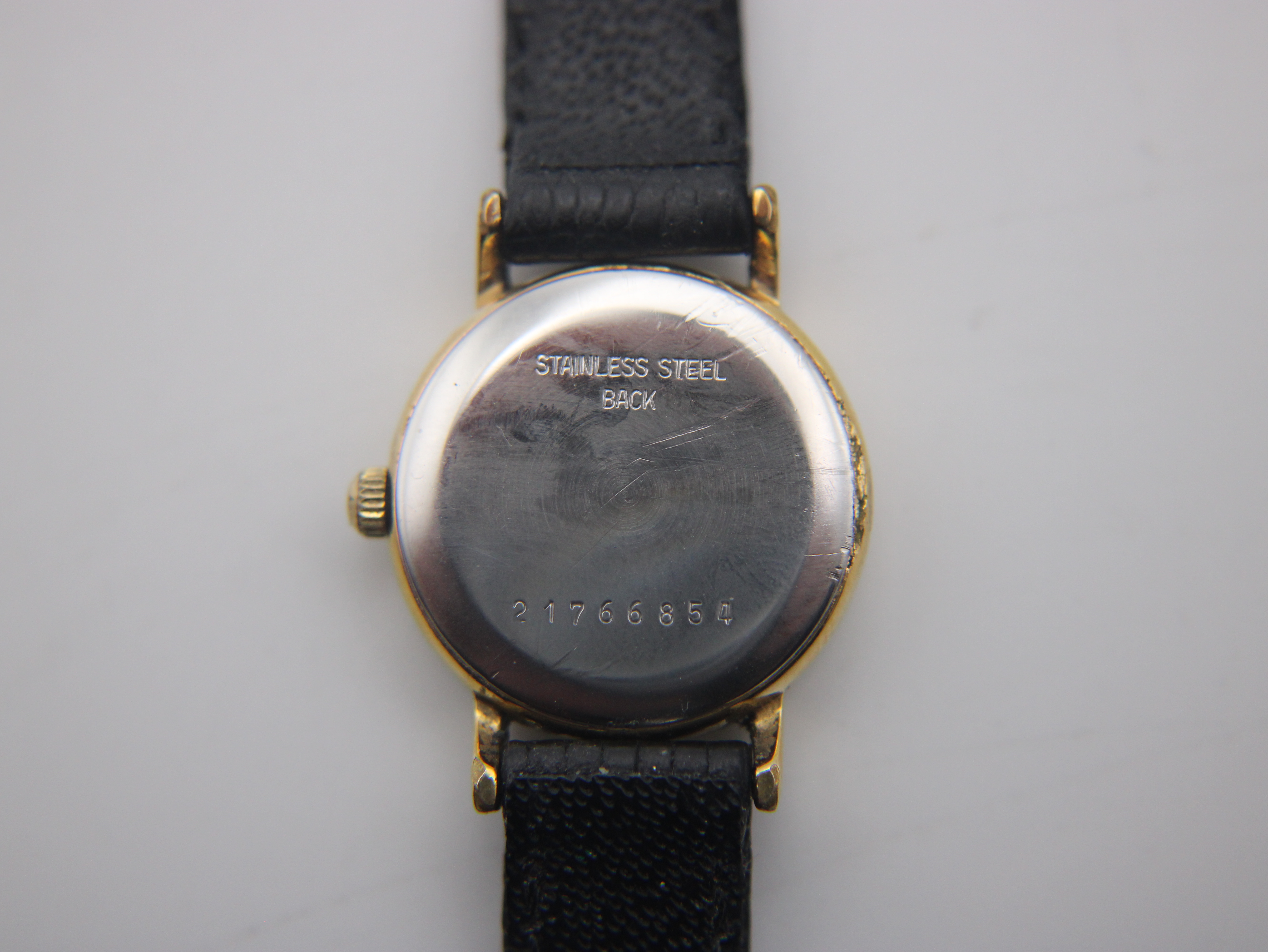 Rear view of the watch case back, with "STAINLESS STEEL BACK" and serial number "21766854" engraved.