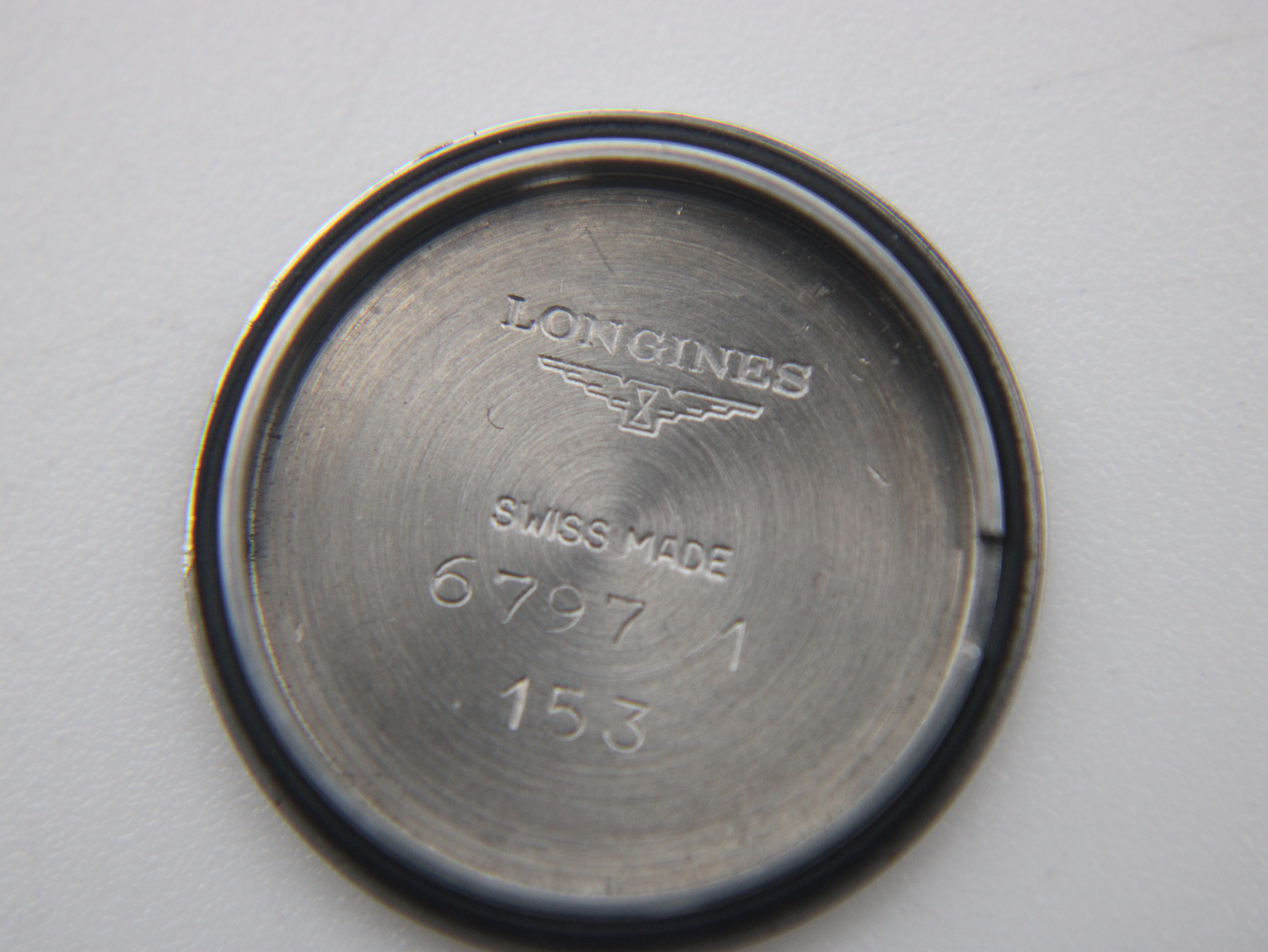 Inside of the stainless steel case back, showing "LONGINES SWISS MADE" and model numbers.