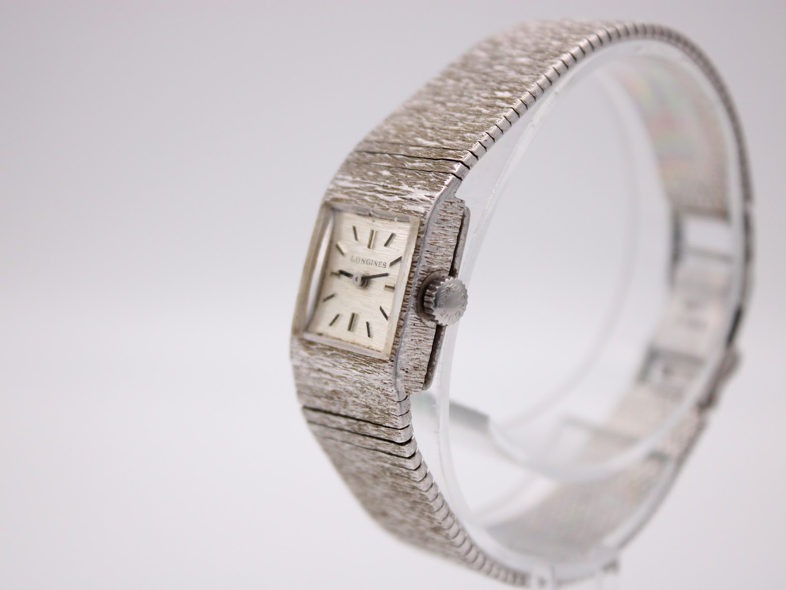 Angled view of the Longines watch showing the textured sterling silver case, crown detail, and bracelet.