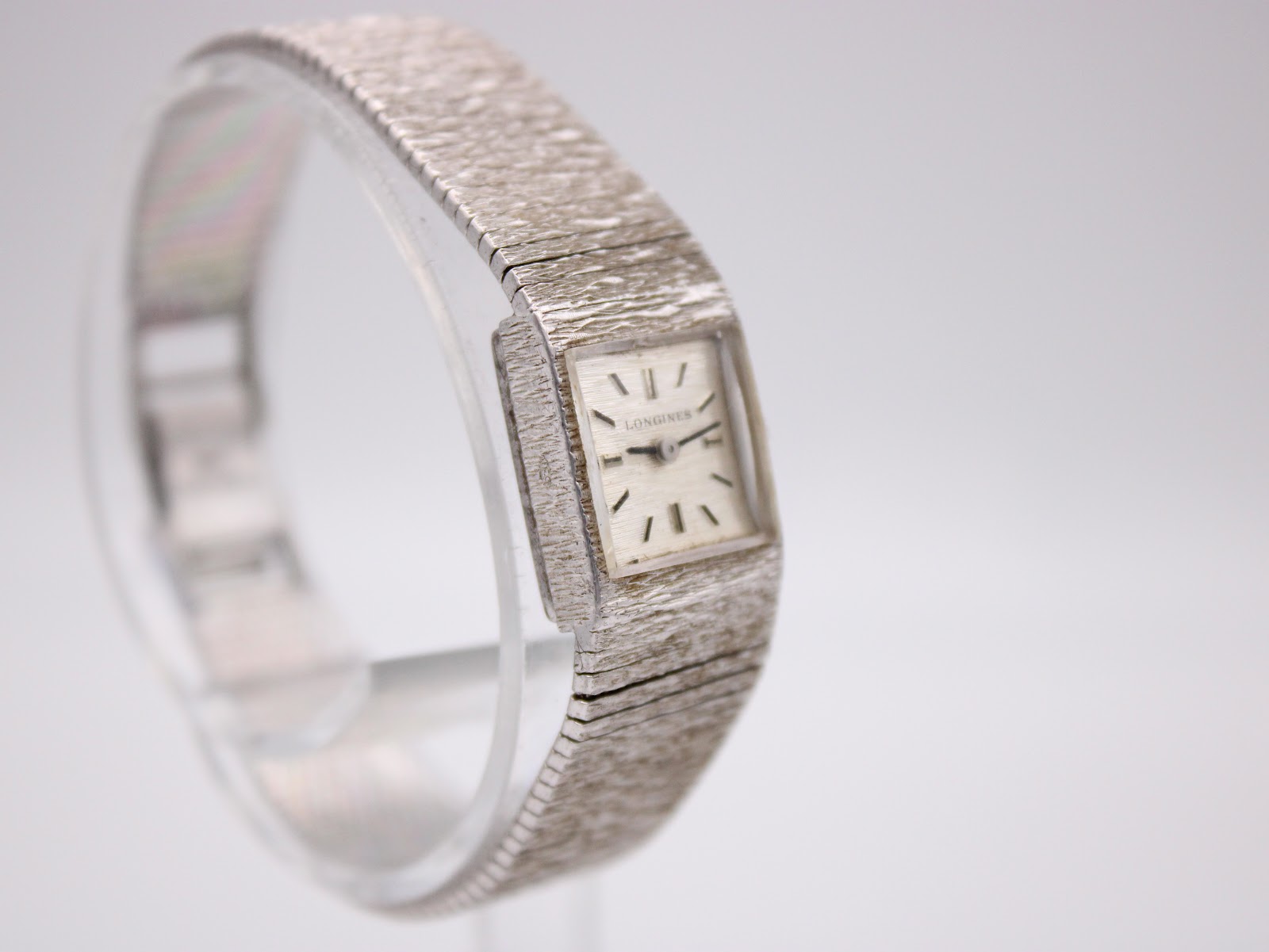 Another angled view of the silver Longines watch, highlighting its square dial and integrated bracelet design.