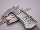 Close-up of a digital caliper measuring the Longines watch case, displaying a precise diameter of 19.35 mm.